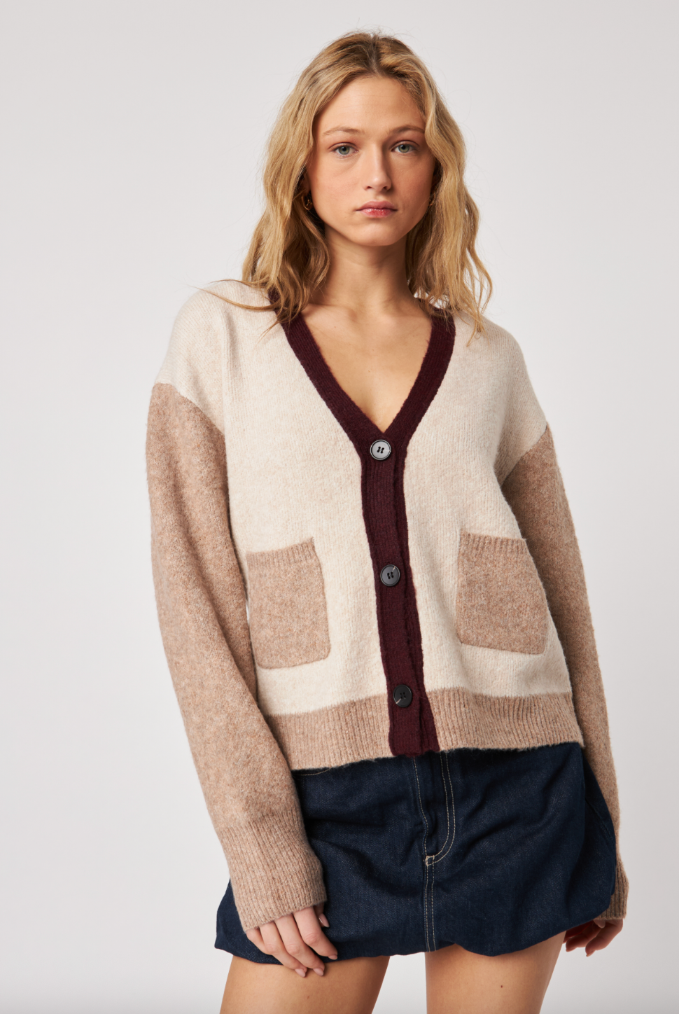 Woman wearing a patterned cardigan with a neutral background