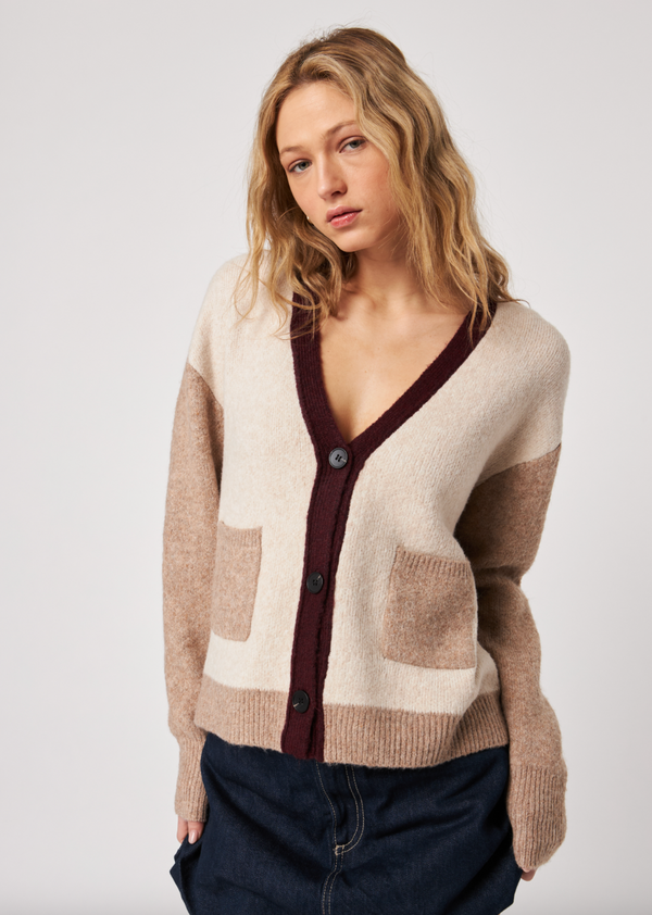 Woman wearing a patterned cardigan on a plain background